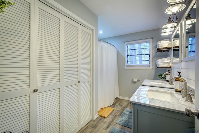 laundry area with light wood-style floors, laundry area, baseboards, and a sink