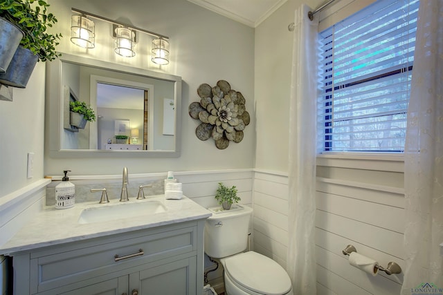 bathroom with toilet, a wainscoted wall, crown molding, and vanity