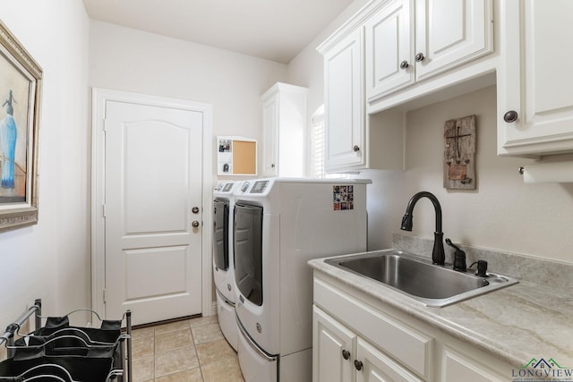 washroom featuring cabinets, light tile patterned flooring, sink, and washer and clothes dryer