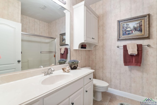 bathroom with vanity, a shower with shower door, tile patterned floors, and toilet