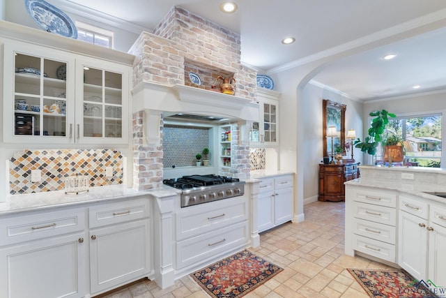 kitchen featuring white cabinetry, light stone countertops, ornamental molding, and stainless steel gas cooktop