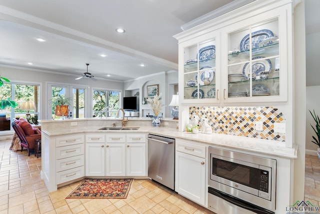 kitchen featuring sink, kitchen peninsula, stainless steel appliances, decorative backsplash, and white cabinets