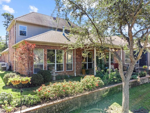 view of front facade with central AC unit and a front yard