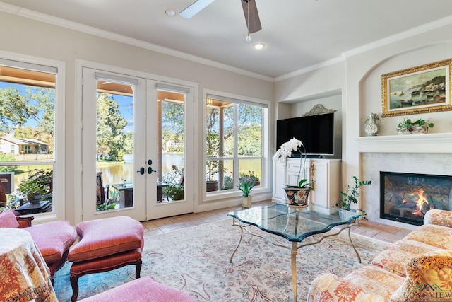 living room with crown molding, built in features, a premium fireplace, french doors, and light wood-type flooring