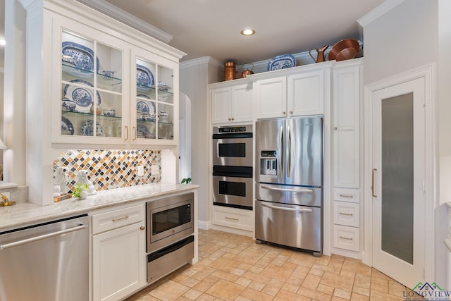 kitchen featuring crown molding, appliances with stainless steel finishes, decorative backsplash, and white cabinets