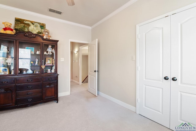 carpeted bedroom with crown molding, a closet, and ceiling fan