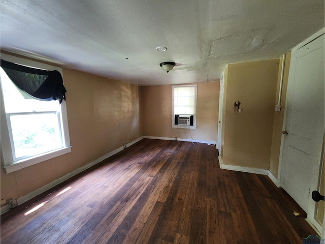 spare room featuring cooling unit and dark hardwood / wood-style flooring