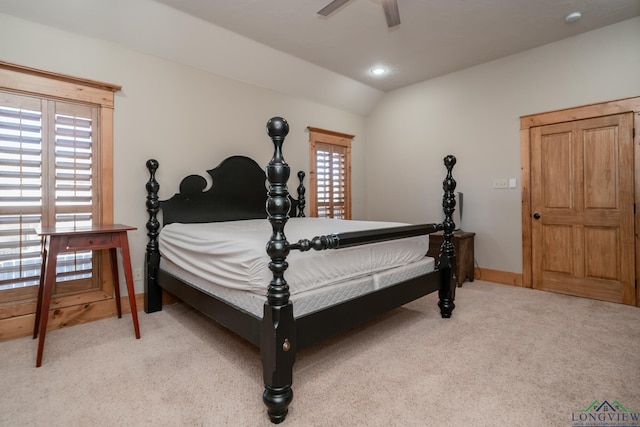 bedroom featuring a ceiling fan, baseboards, light colored carpet, and vaulted ceiling