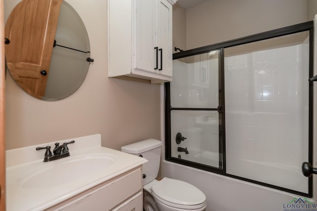 bathroom featuring vanity, enclosed tub / shower combo, and toilet