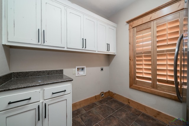 laundry room with stone finish floor, hookup for an electric dryer, washer hookup, cabinet space, and baseboards