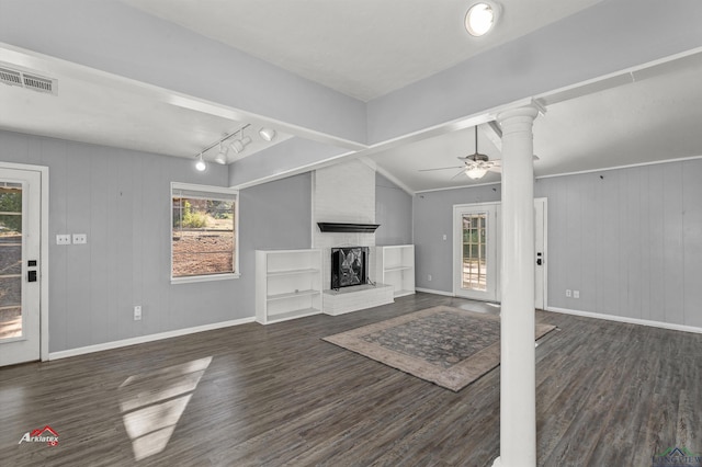 unfurnished living room with lofted ceiling, track lighting, dark hardwood / wood-style floors, ceiling fan, and a fireplace