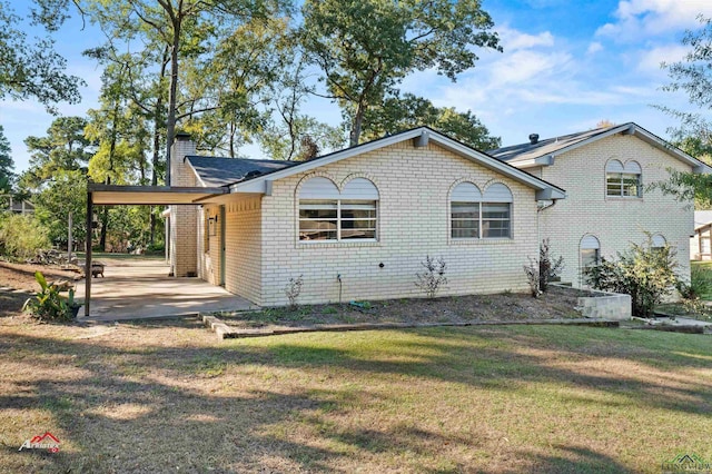 view of home's exterior with a carport and a yard