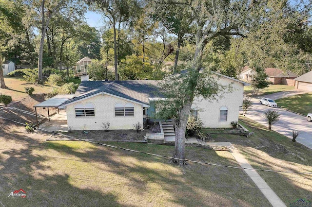 view of front of home with a front yard and a carport