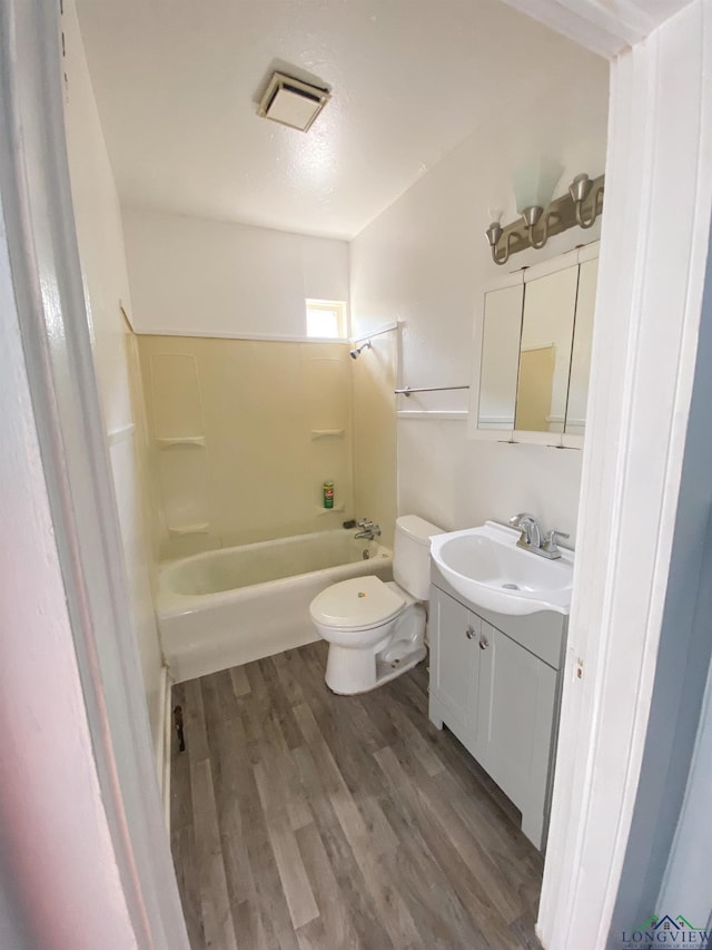 full bathroom featuring wood-type flooring, toilet, shower / bath combination, and vanity