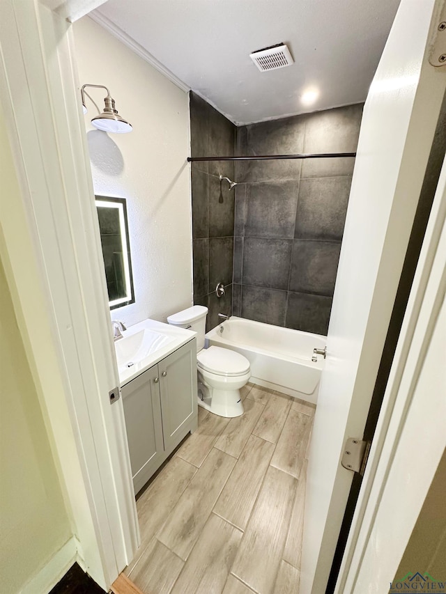 full bathroom featuring vanity, toilet, and tiled shower / bath