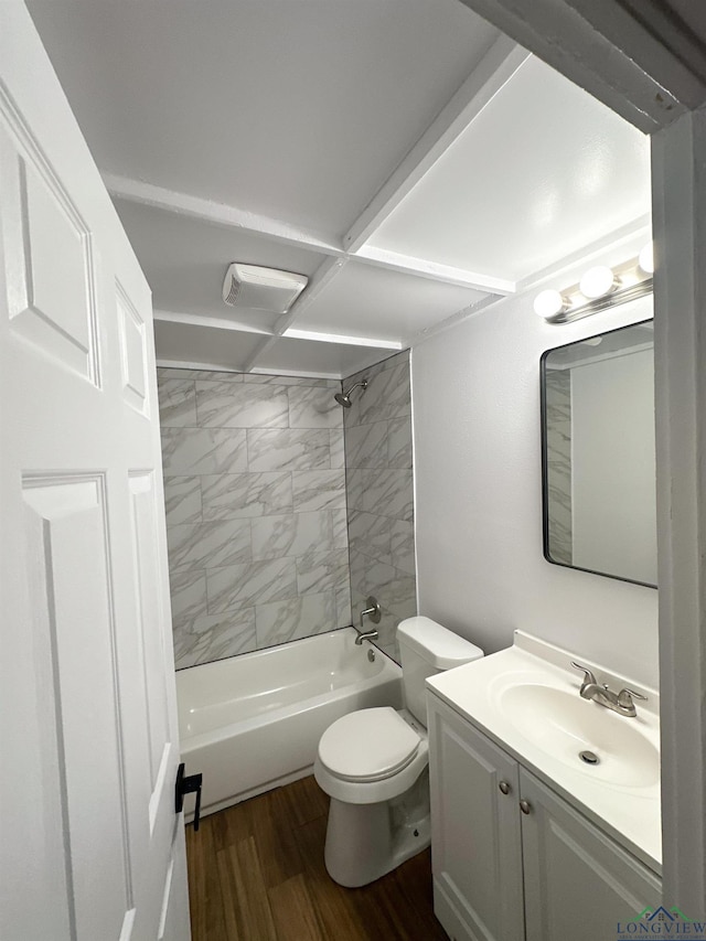 full bathroom featuring tiled shower / bath combo, wood-type flooring, vanity, and toilet