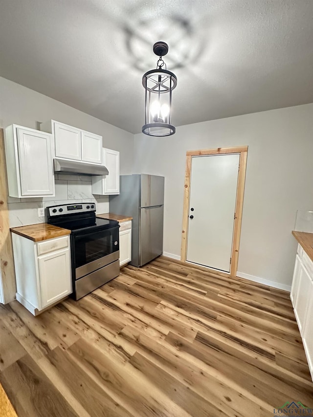 kitchen featuring butcher block counters, white cabinetry, hanging light fixtures, light hardwood / wood-style flooring, and appliances with stainless steel finishes