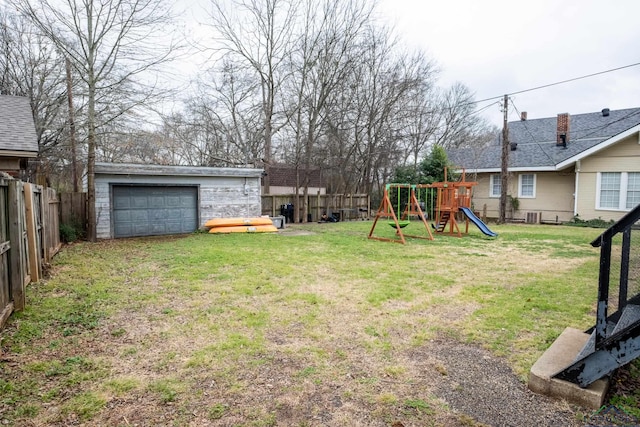 view of yard with a playground, a garage, an outbuilding, and central air condition unit