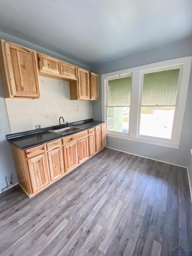 kitchen with sink, light wood-type flooring, and decorative backsplash