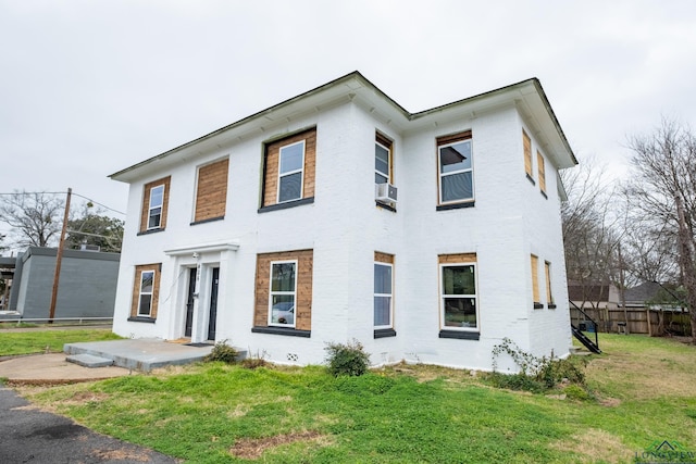 view of front of property featuring a patio, a front yard, and cooling unit