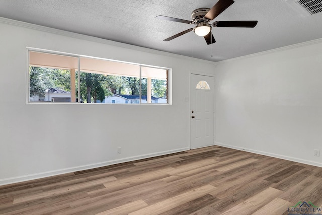 unfurnished room featuring a wealth of natural light, ceiling fan, hardwood / wood-style flooring, and ornamental molding