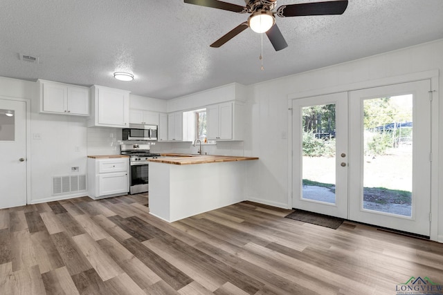 kitchen featuring white cabinets, appliances with stainless steel finishes, wood counters, and french doors