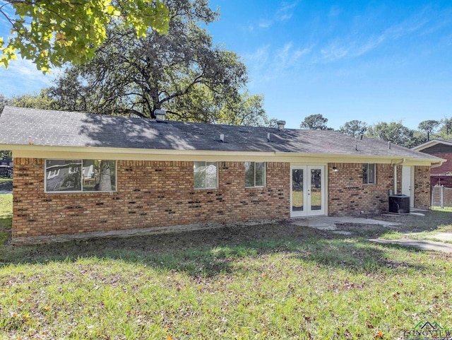 back of property featuring french doors, a lawn, and central air condition unit