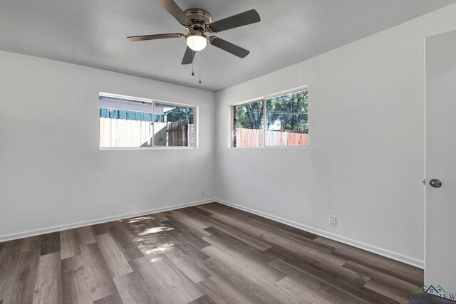 empty room with dark hardwood / wood-style flooring and ceiling fan