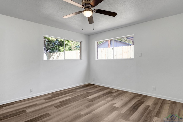 spare room featuring ceiling fan, wood-type flooring, and a textured ceiling