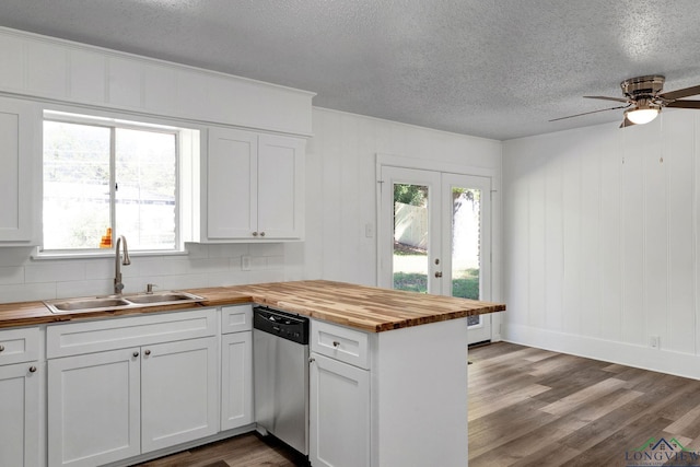 kitchen with dishwasher, white cabinetry, butcher block counters, and sink