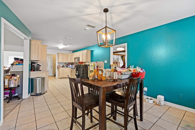 tiled dining area featuring an inviting chandelier