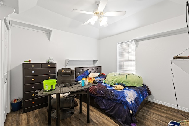 bedroom with dark hardwood / wood-style floors, a raised ceiling, and ceiling fan