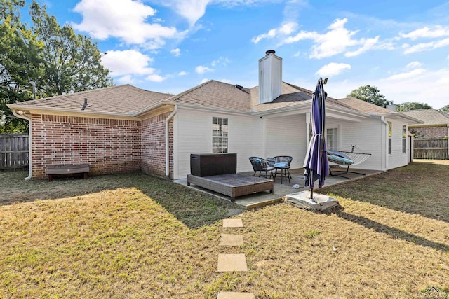 rear view of house with a patio area and a lawn