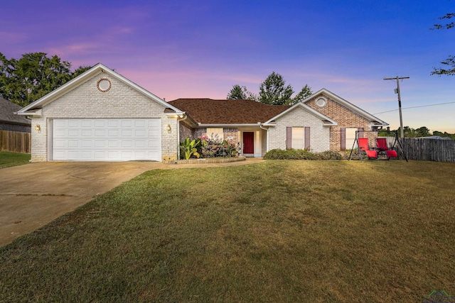 single story home featuring a garage and a lawn