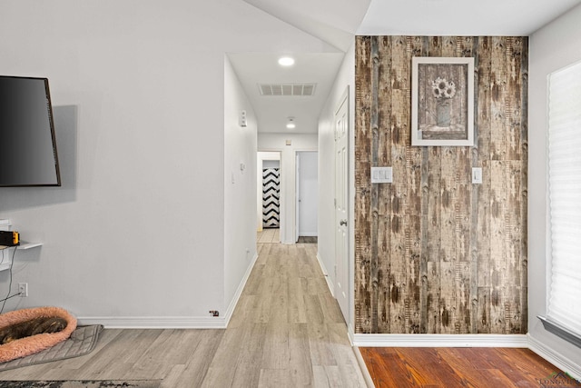 hall featuring wood walls and light hardwood / wood-style floors