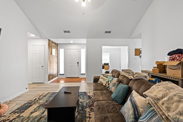 living room featuring ceiling fan, high vaulted ceiling, and light hardwood / wood-style flooring