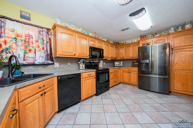 kitchen featuring sink, a textured ceiling, decorative backsplash, light tile patterned floors, and black appliances