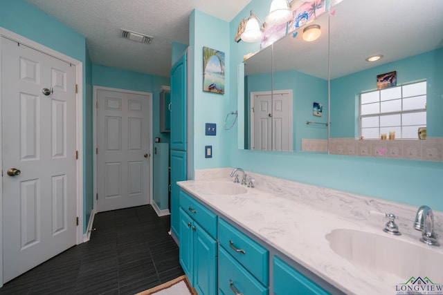 bathroom featuring tile patterned flooring, vanity, and a textured ceiling