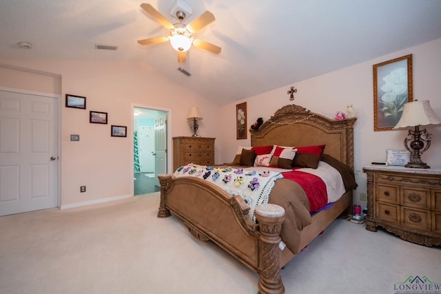 carpeted bedroom with ceiling fan, ensuite bathroom, and vaulted ceiling