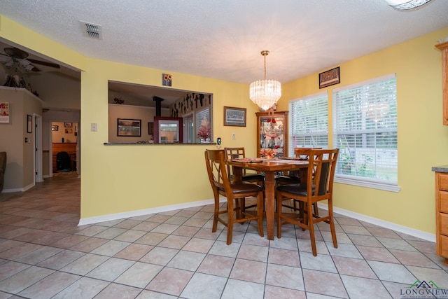 dining room featuring a notable chandelier, light tile patterned floors, and a textured ceiling