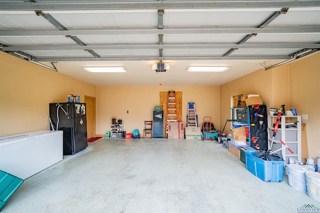 2120 Page Rd, Longview, TX 75601 - garage featuring freestanding refrigerator, refrigerator, and a garage door opener
