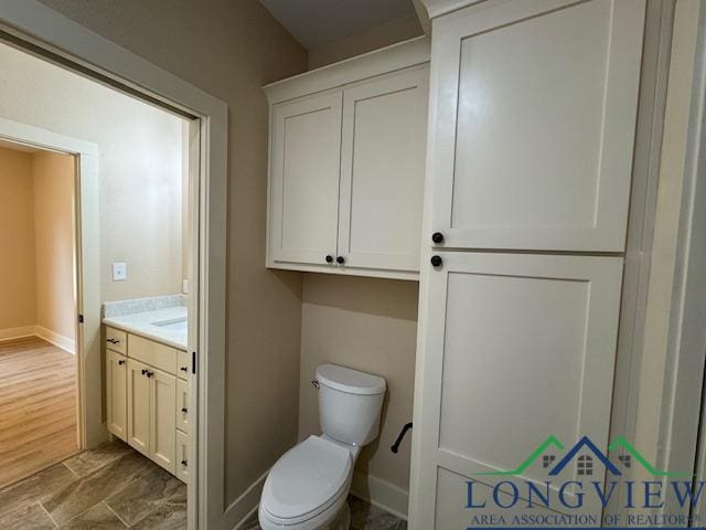 bathroom with vanity, toilet, and wood-type flooring