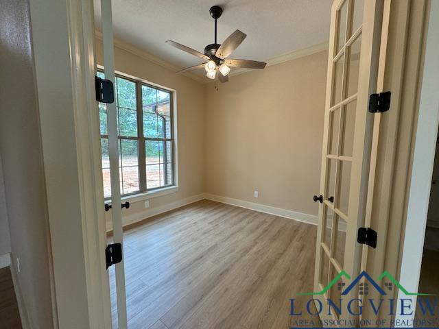 unfurnished room with hardwood / wood-style flooring, ceiling fan, ornamental molding, and french doors