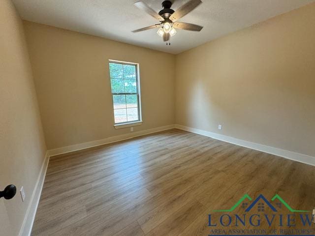 empty room with ceiling fan and light wood-type flooring