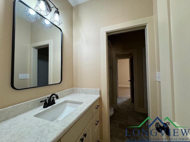 bathroom featuring tile patterned floors, vanity, and toilet