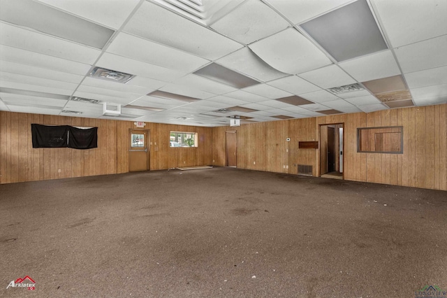 707 Willow St, Carthage, TX 75633 - carpeted spare room featuring wood walls and a paneled ceiling