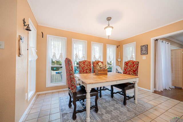 dining area featuring light tile patterned flooring, ornamental molding, and a wealth of natural light