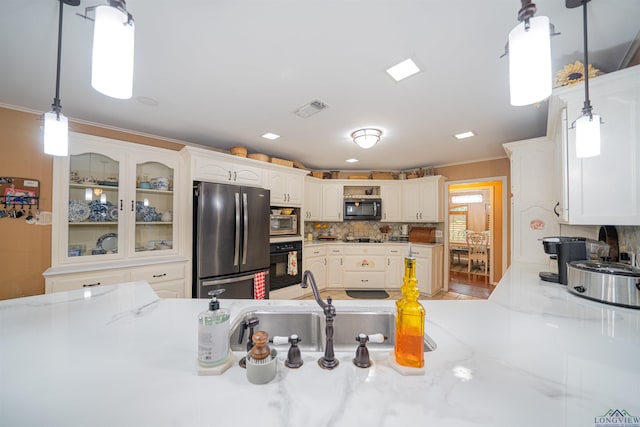 kitchen with white cabinetry, stainless steel appliances, tasteful backsplash, crown molding, and decorative light fixtures