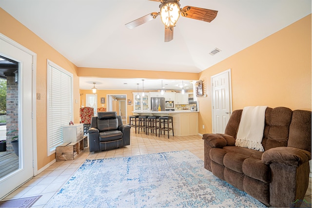 living room with ceiling fan, light tile patterned floors, and lofted ceiling