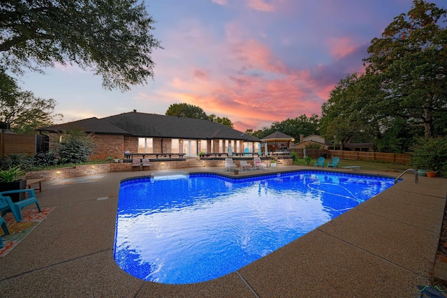 pool at dusk with a patio